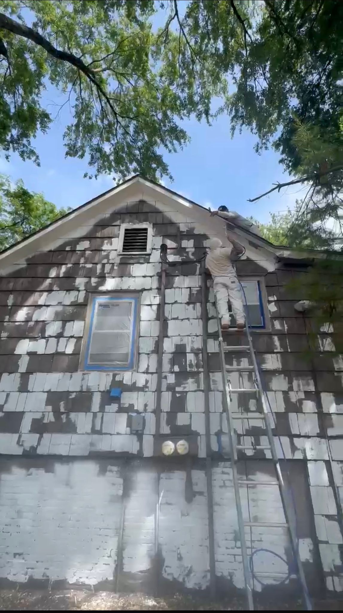 Painter on ladder working on porch during exterior project
