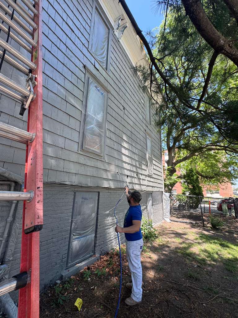 House exterior mid-project during full repaint